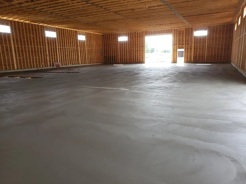 Large commercial concrete floor framed and prepped for placement inside a steel building