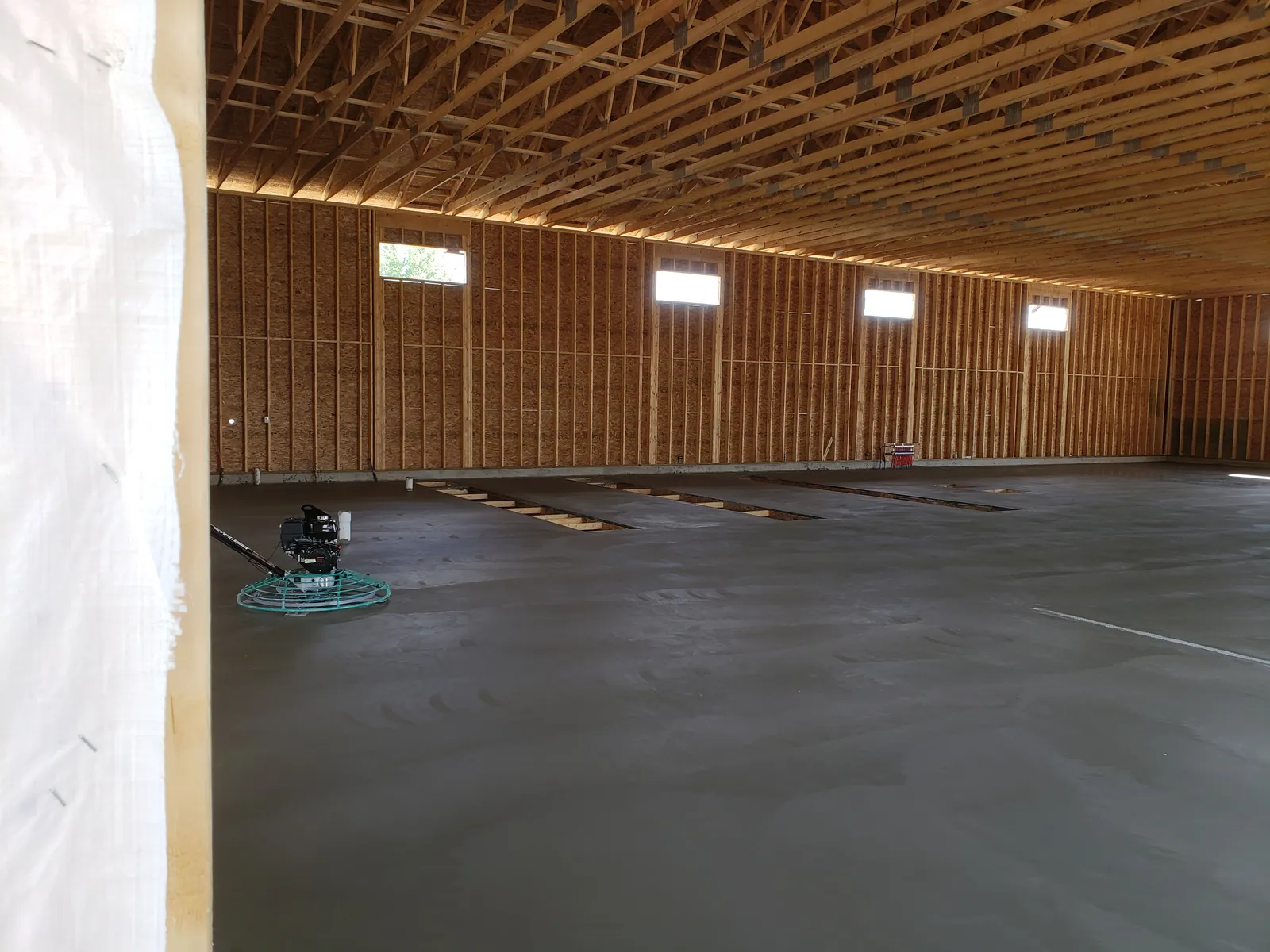Power-troweled commercial concrete floor finished smooth and level in Mid-Michigan