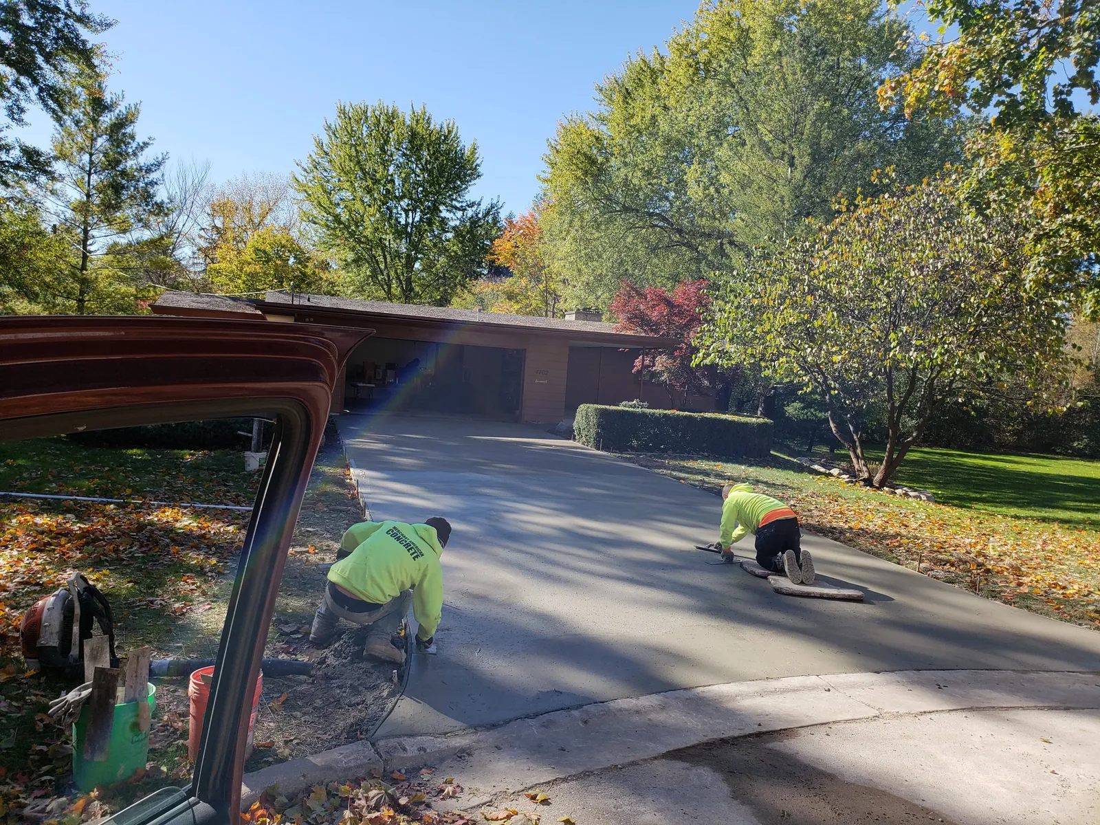 Concrete crew finishing a fresh residential driveway in Bay City, Michigan