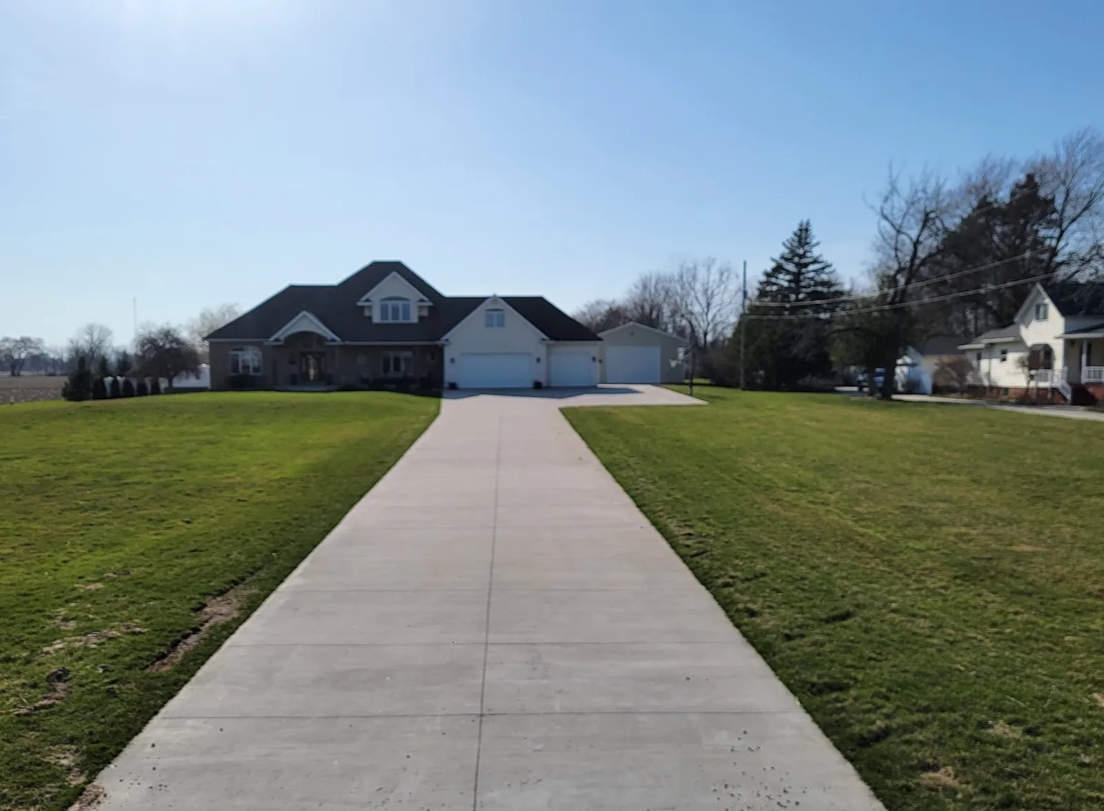 Long, freshly finished concrete driveway leading to a brick home in Bay City, Michigan